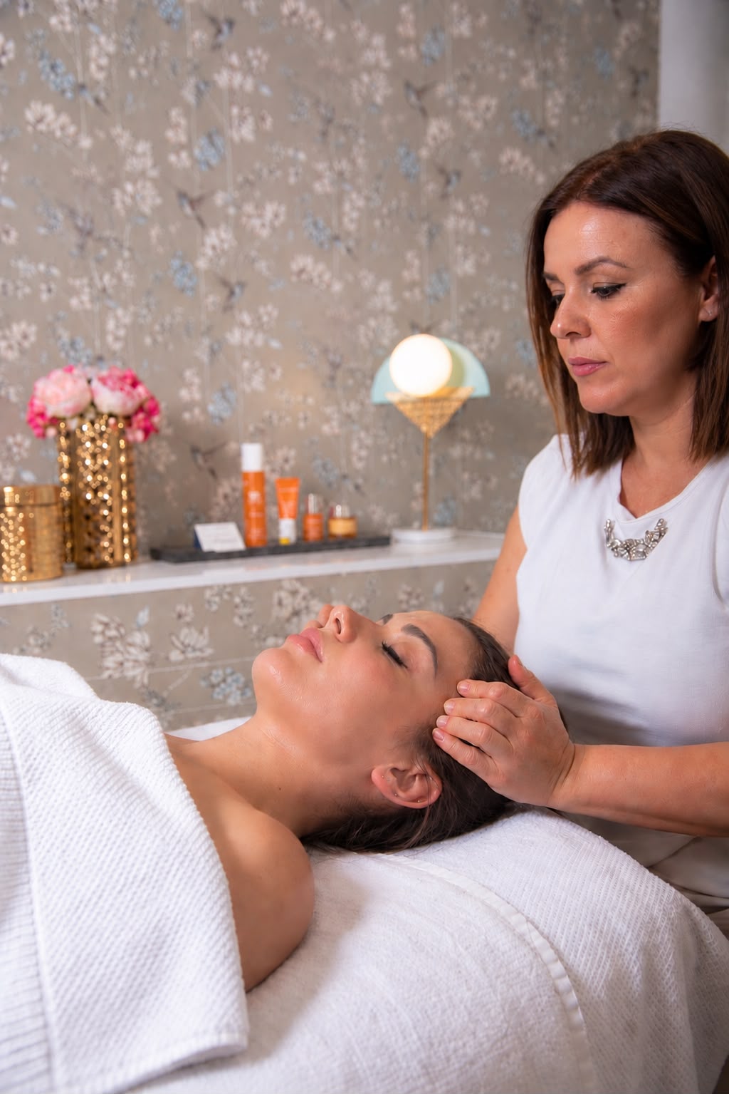 Esteticista realizando un masaje facial a una clienta en cabina